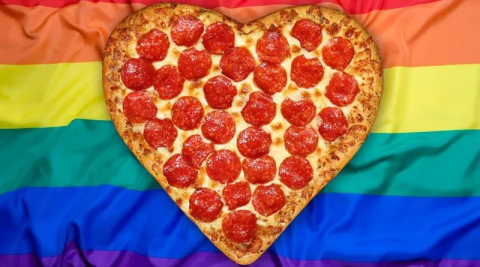 heart shaped pizza over rainbow flag